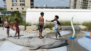 Children playing on a whale sculpture at Sandpiper Playground in Rockaway, Queens.